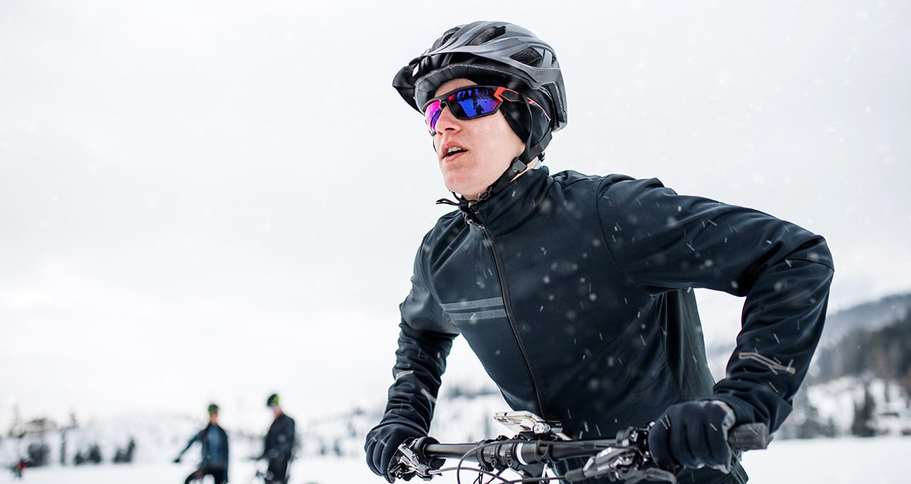 Ciclista in MTB che pedala sulla neve